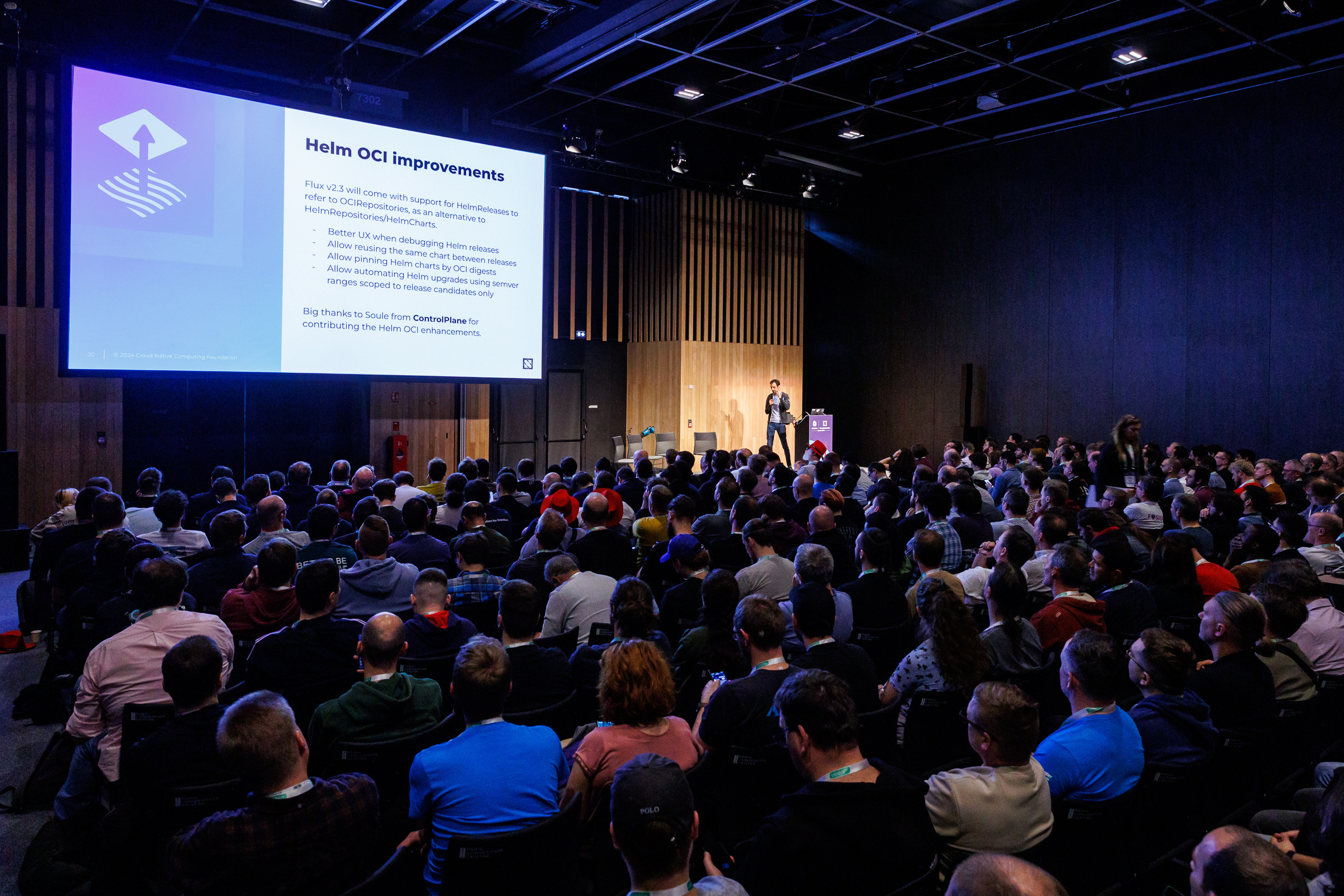 Stefan Prodan speaking to a crowd at KubeCon